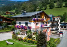 Modernes Wohnhaus der Schwaiger Appartements mit Blumen, Garten und Berglandschaft in Zell am See.
